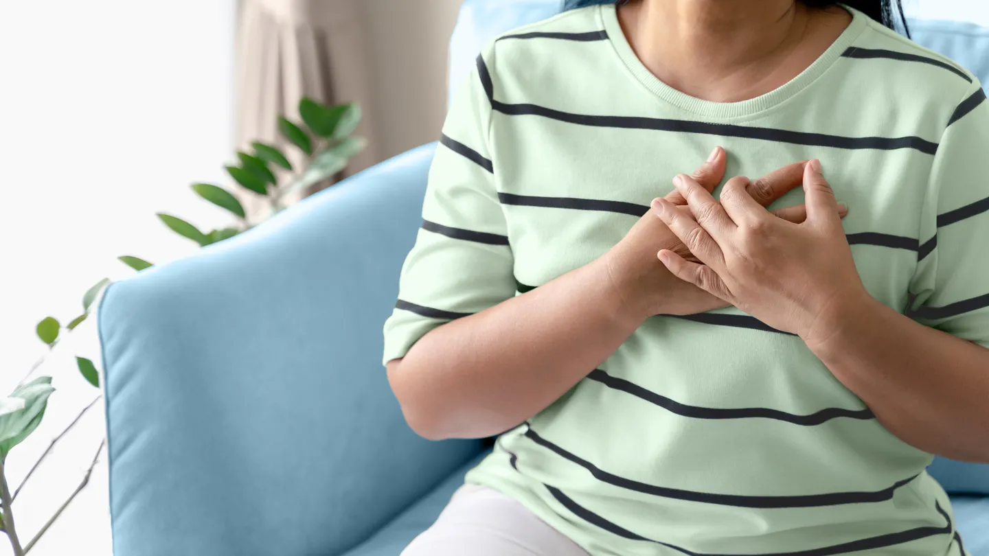 mature woman having heart issues touching her chest
