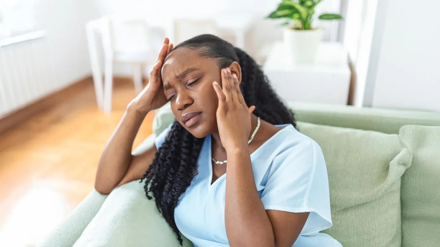 Black woman suffering from migrane at home
