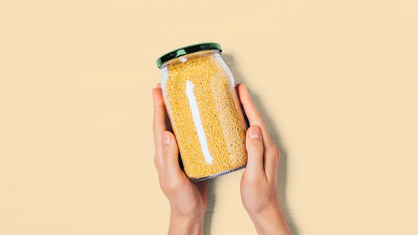 hands holding jar of millet