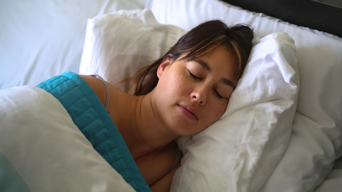 woman sleeping on many pillows