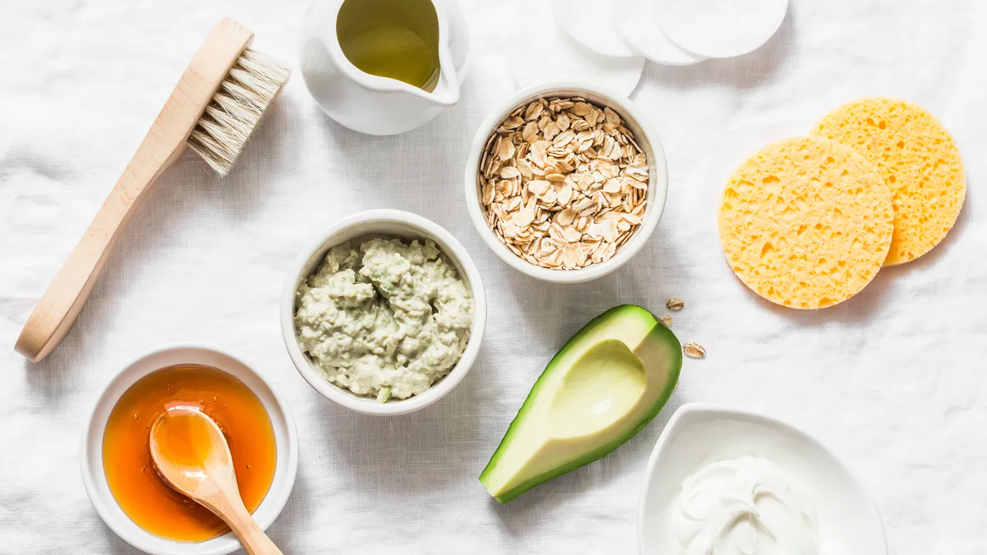 Still life overhead view of honey, avocado, olive oil and coconut for DIY skin care