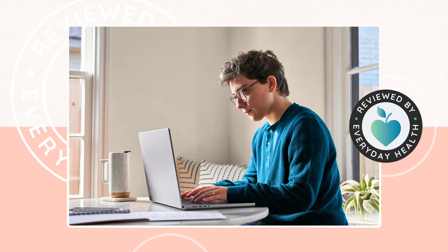 Person sitting at a table in their home on a laptop