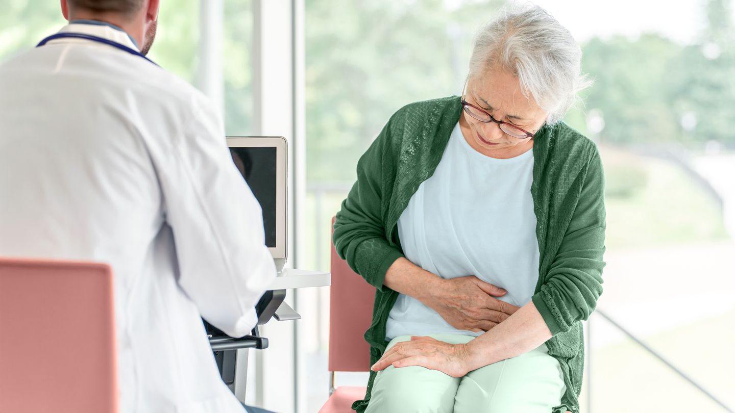 senior woman in abdominal pain at the doctor