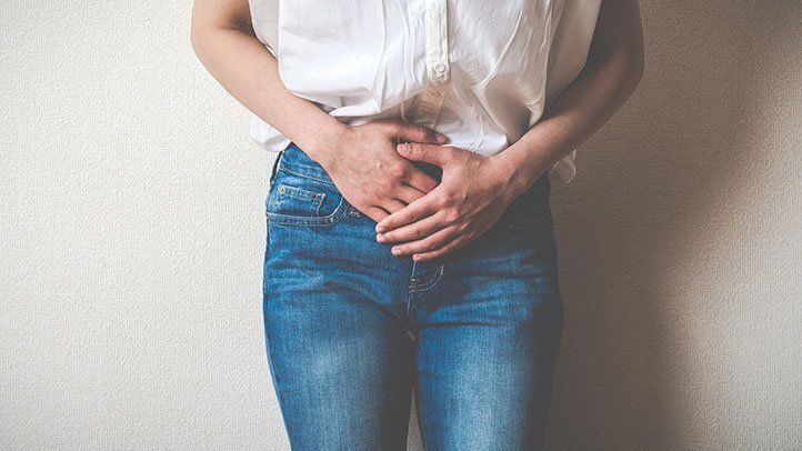 a woman feeling symptoms of ovarian cancer