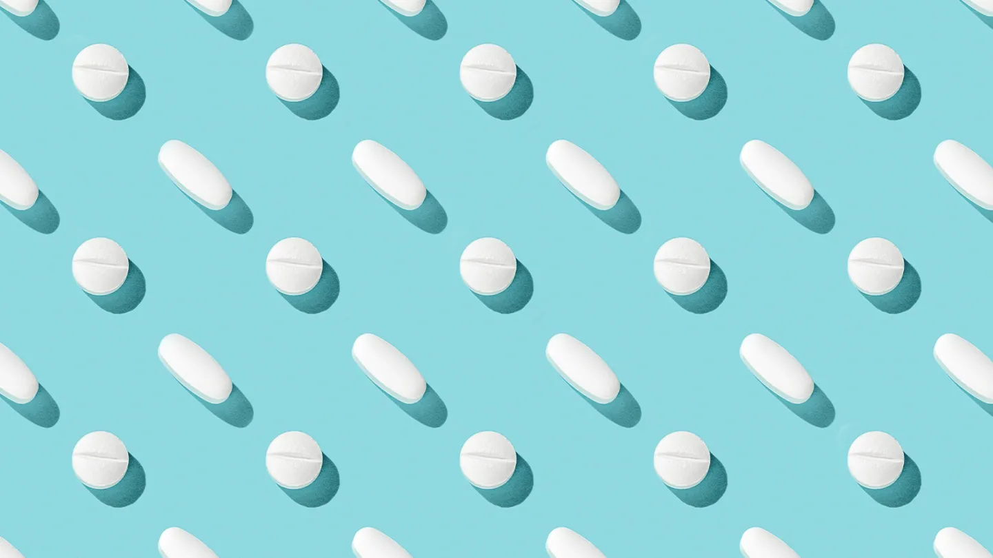 generic white pills repeating on a blue background