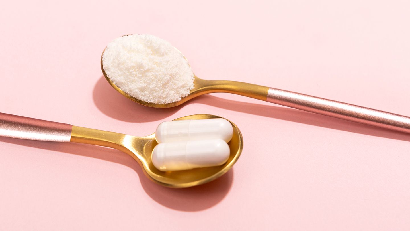 collagen powder and supplements in golden spoons on pink