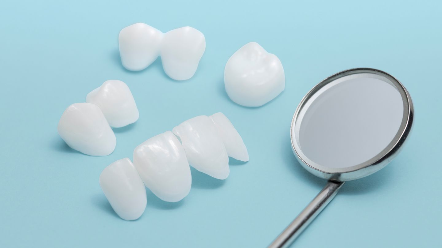 Dental veneers and dental mirror against blue