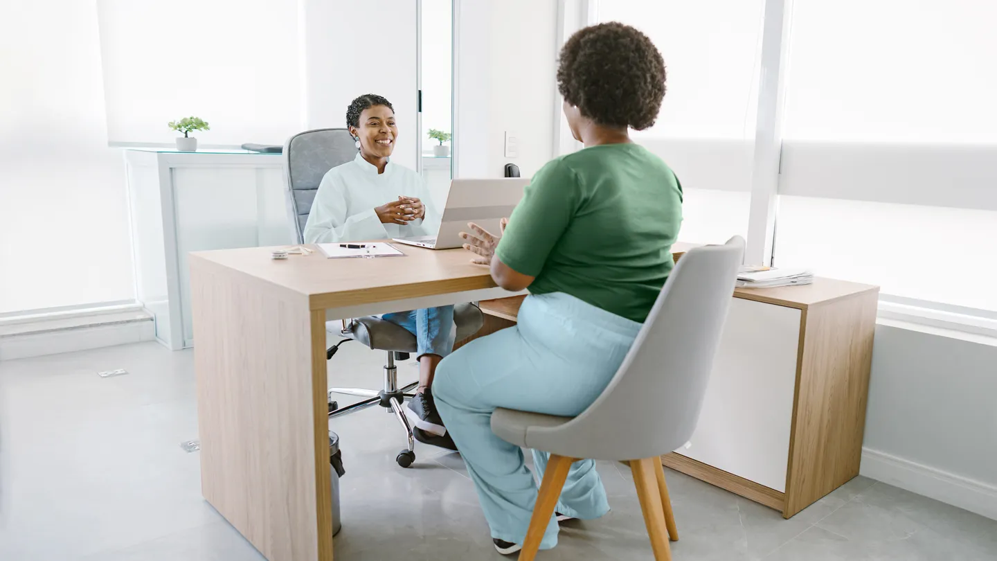 over weight female patient talking with her doctor in the office