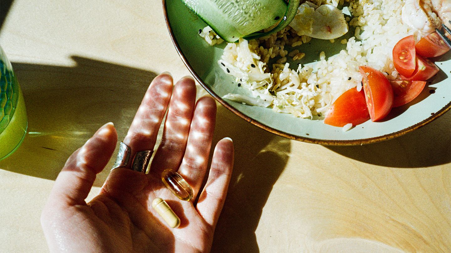 woman eating holding vitamins