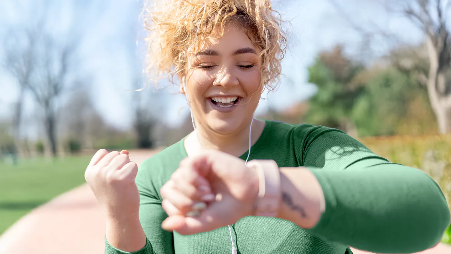 plus size young woman tracking steps in the park