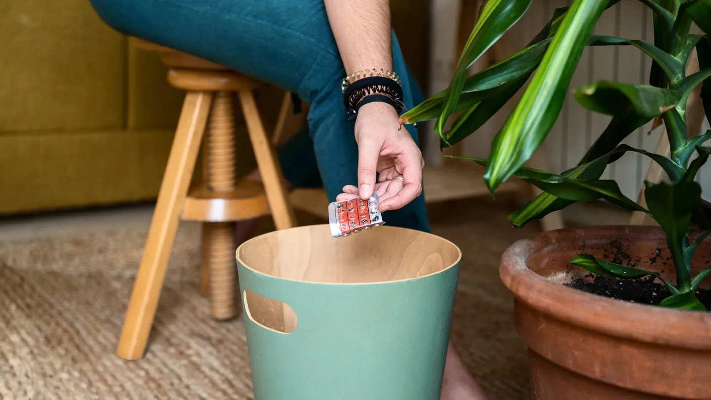 woman throwing away birth control pill packet