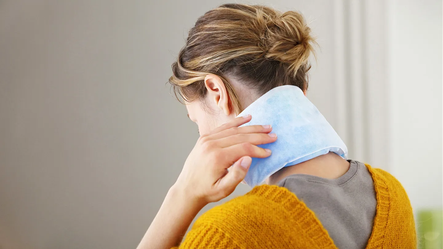woman holding ice pack on neck