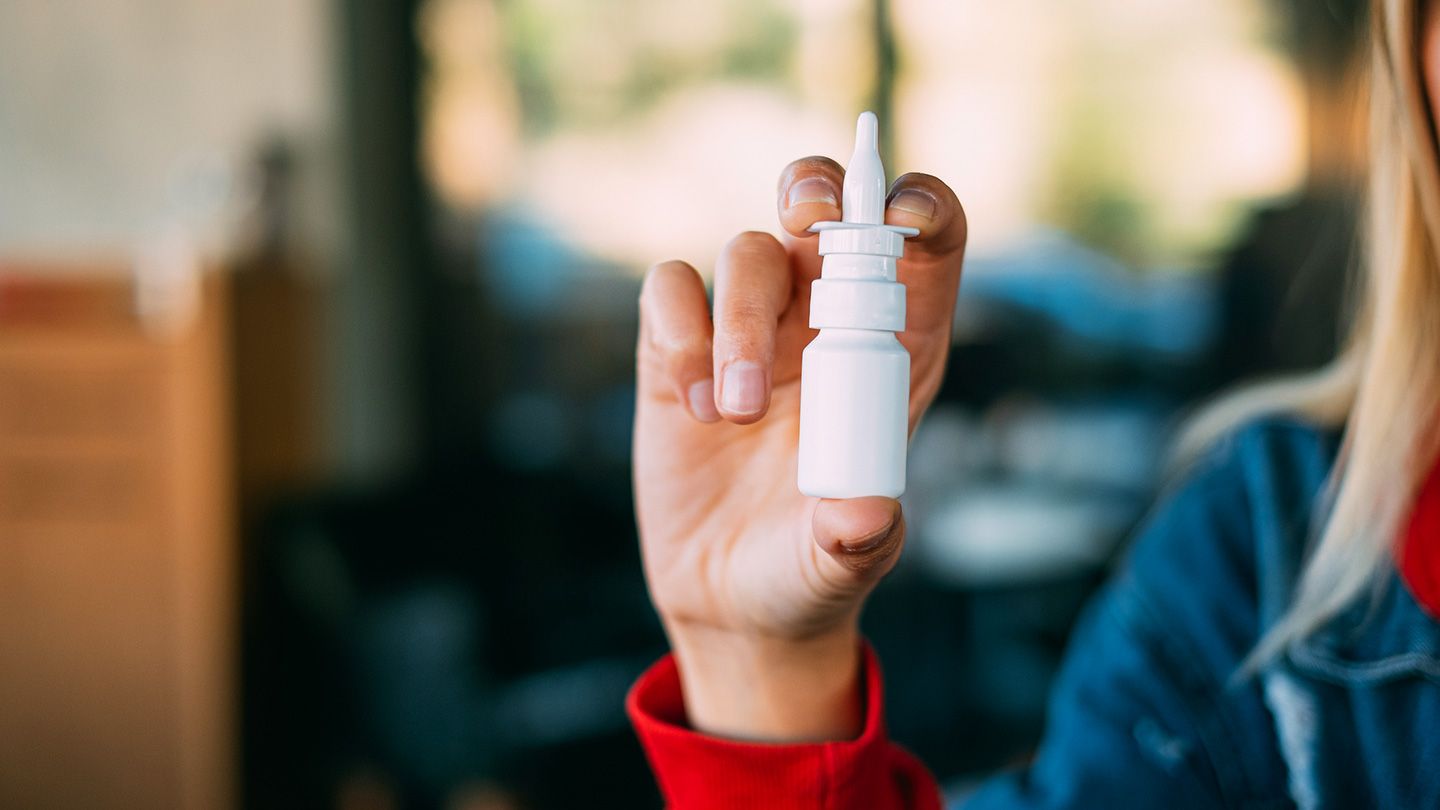 woman holding allergy nasal spray