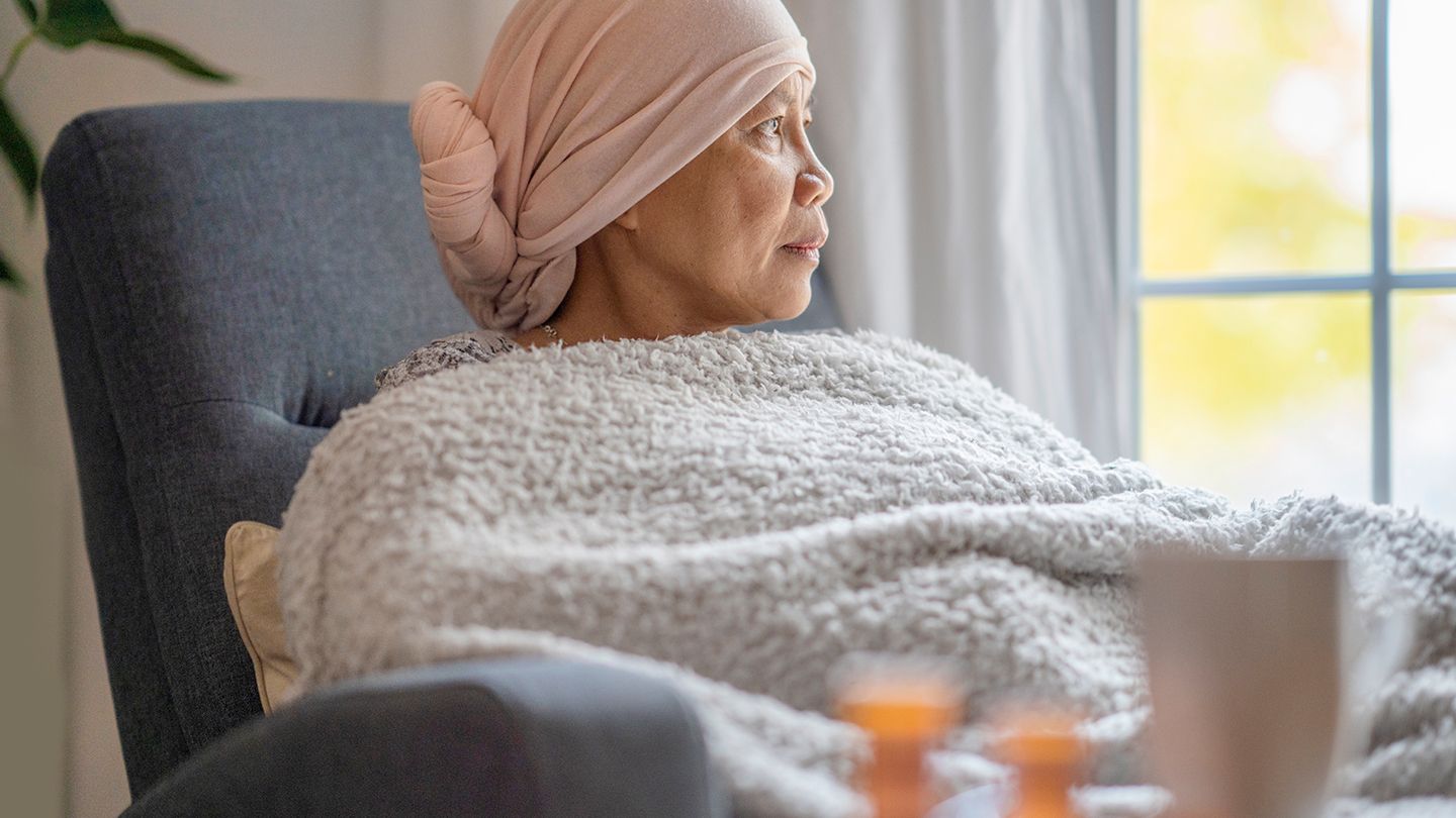 woman looking out window during chemo treatment