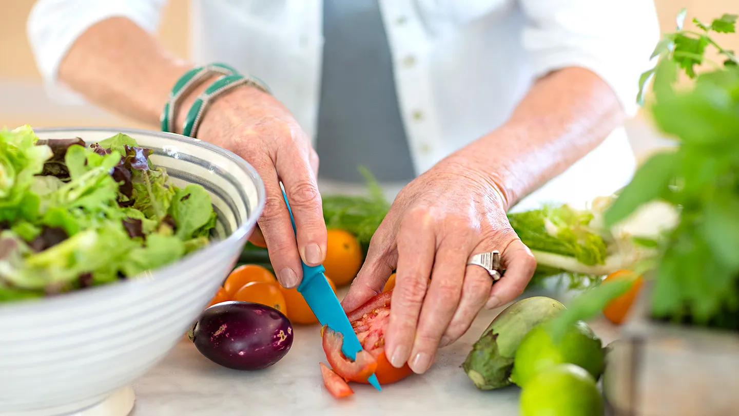 senior woman cutting vegetables