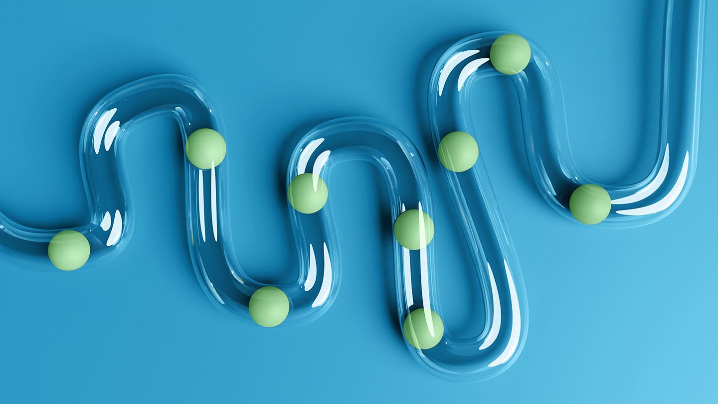 green balls moving through through plastic see through intestines shape tube on blue