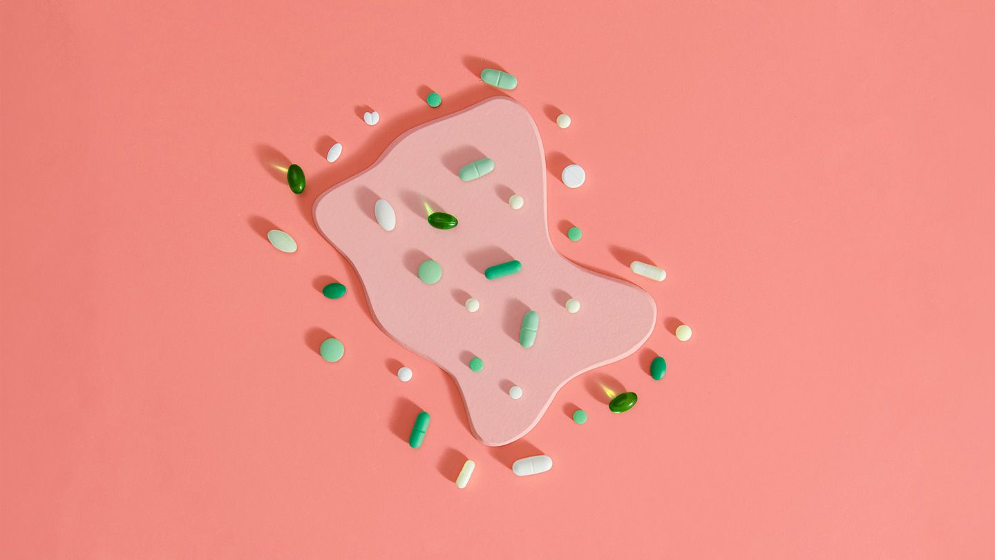 Top view on pills on coral background on top of organic shape like agitation inside digestive system