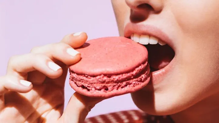 a woman eating a macaron