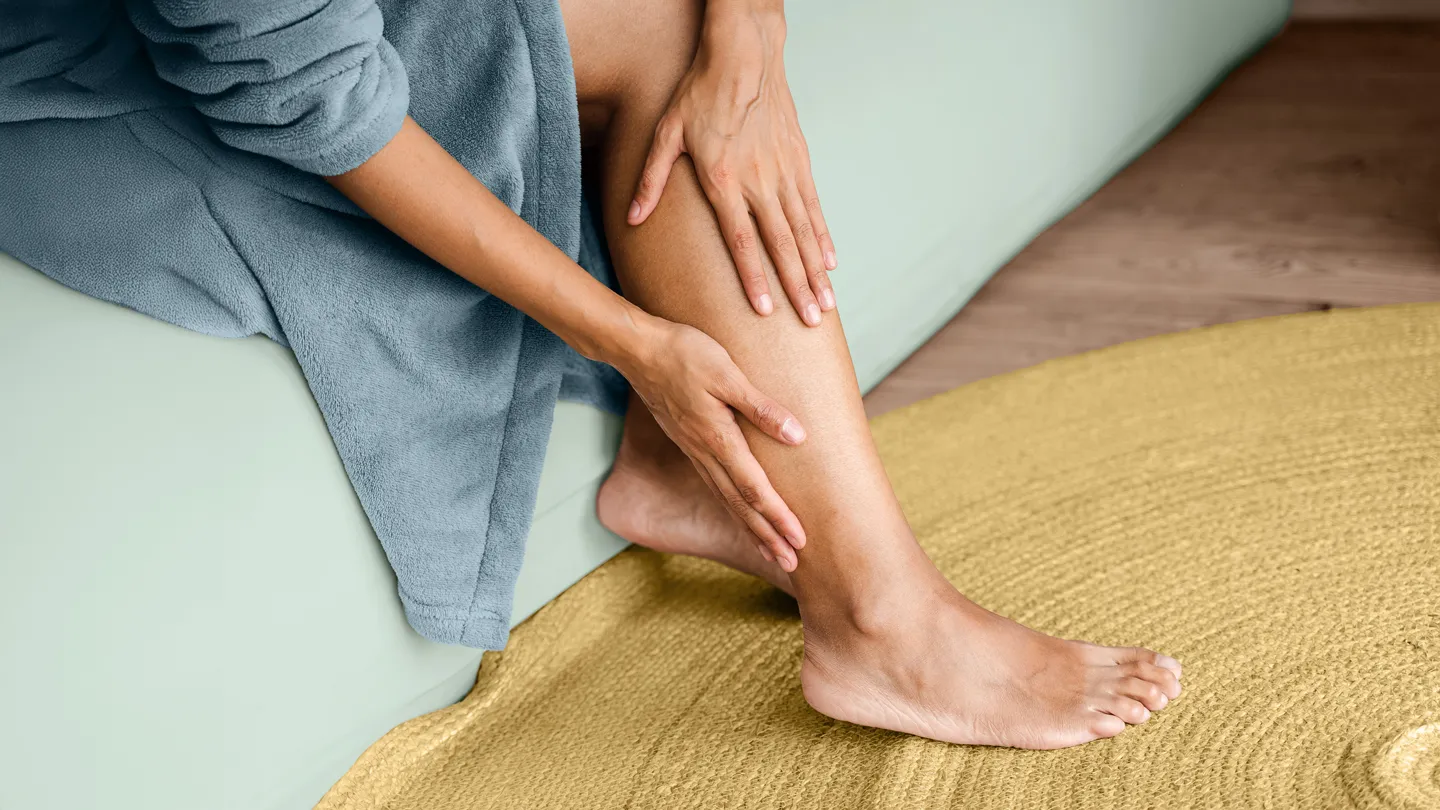 woman holding her lower leg, experiencing foot pain