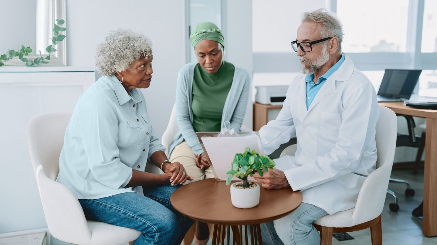 doctor consulting with Black woman patient with cancer and her senior mother