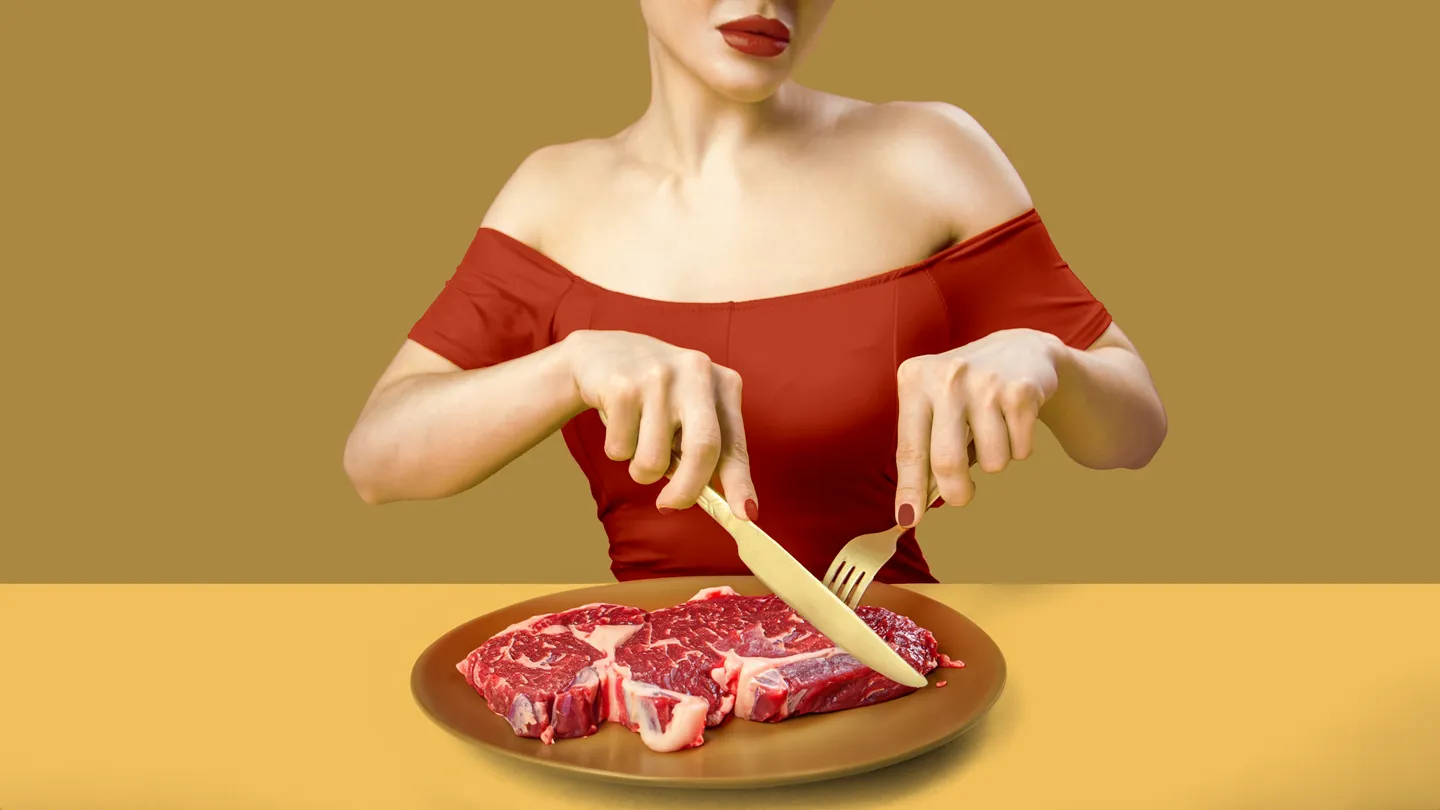 woman cutting into a raw steak carnivore diet
