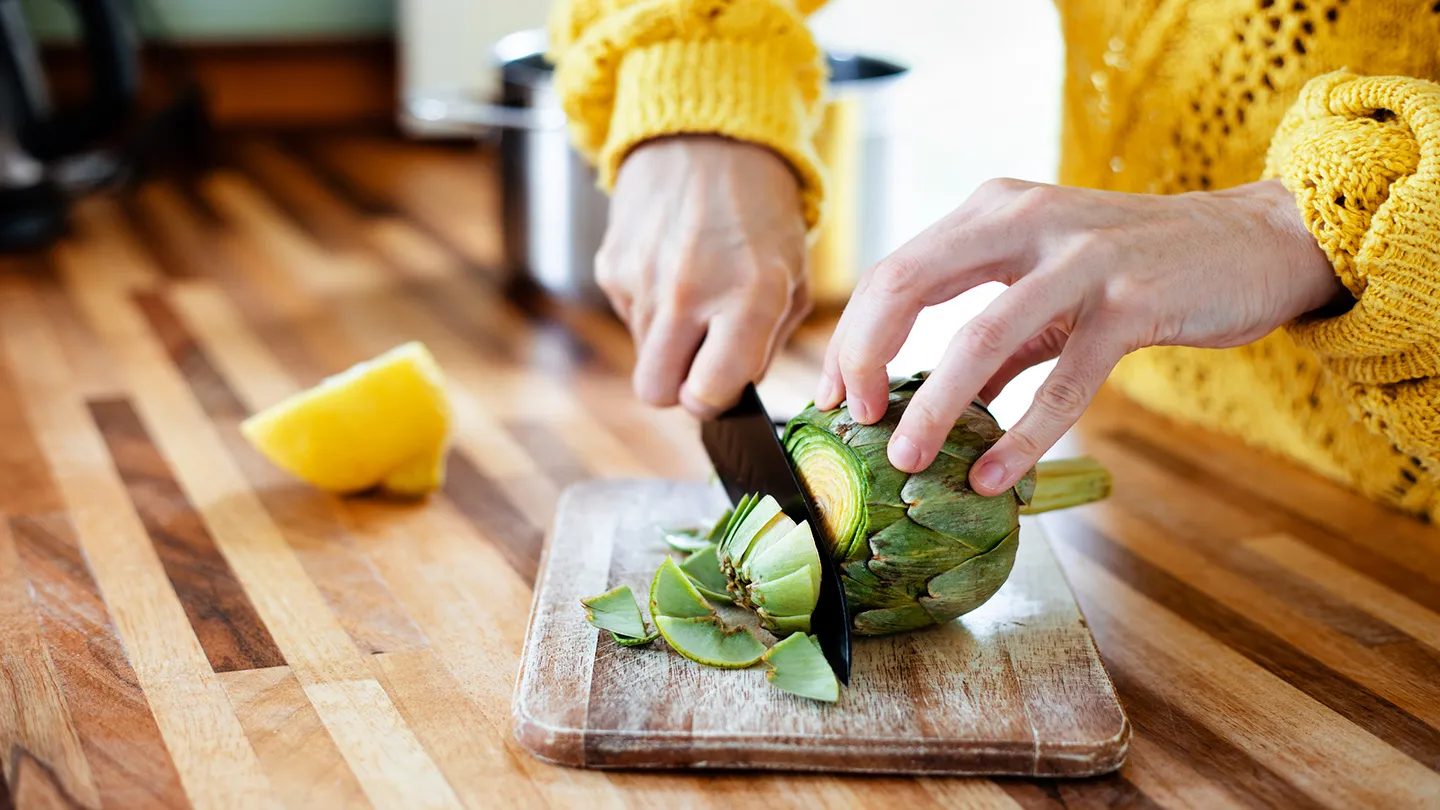 woman cutting fiber full artichoke