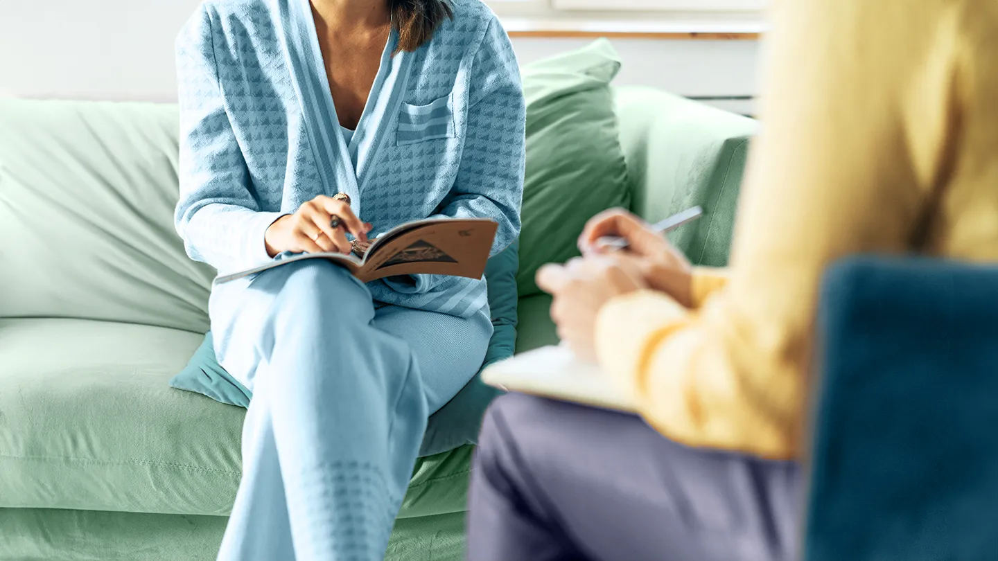 woman talking to gastrointestinal psychologist with notebook and clipboard