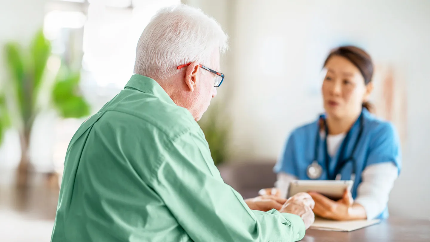 Senior man meeting with his female doctor to discuss some lung health concerns and scans
