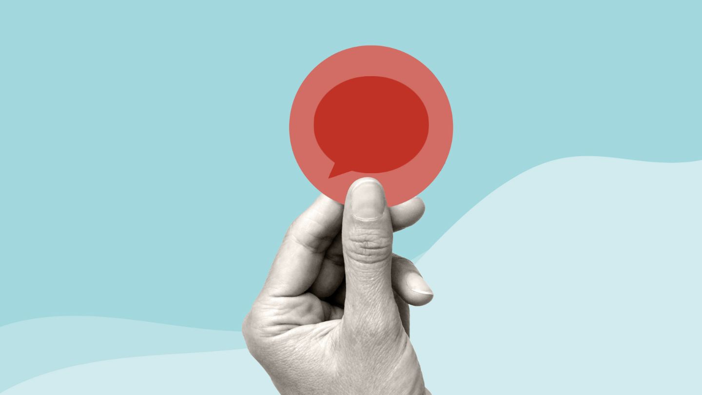 hand holding a speech bubble in red