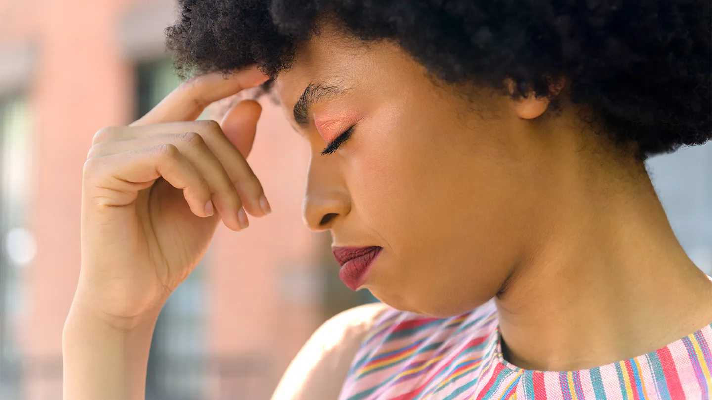 woman with migraine outdoors