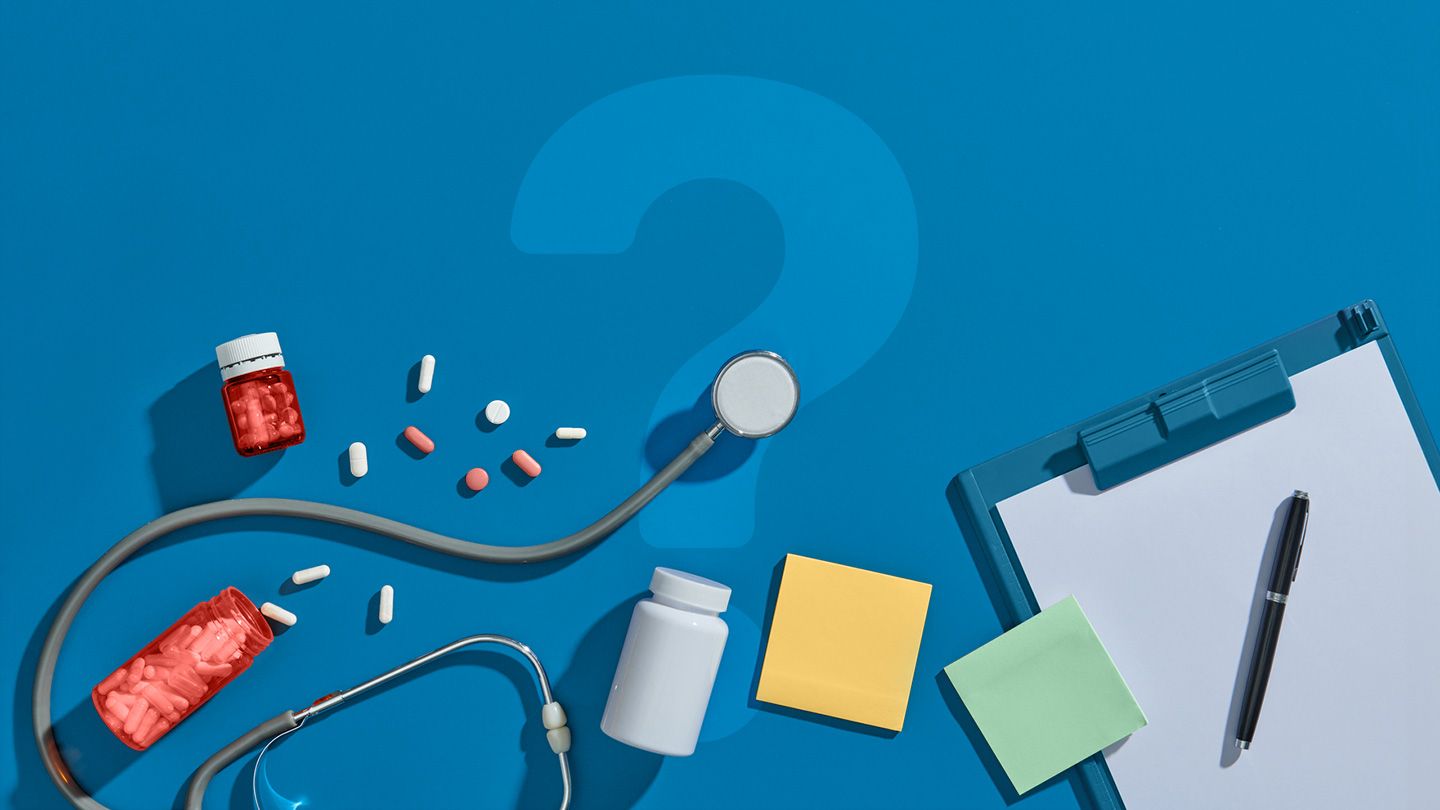 assorted pills pill bottles stethoscope sticky notes a clipboard and pen on blue with a question mark behind