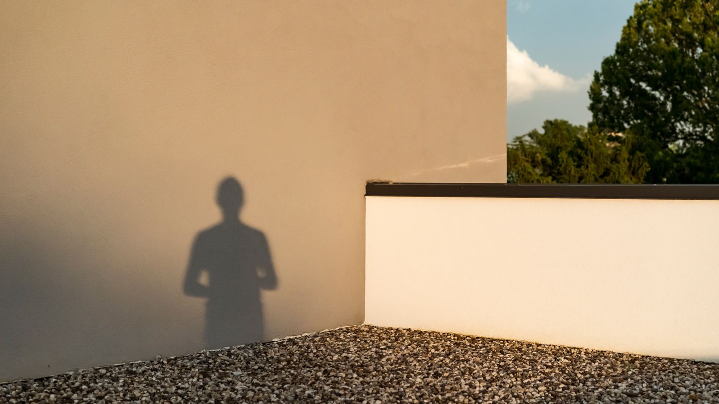 lone shadow figure rooftop wall