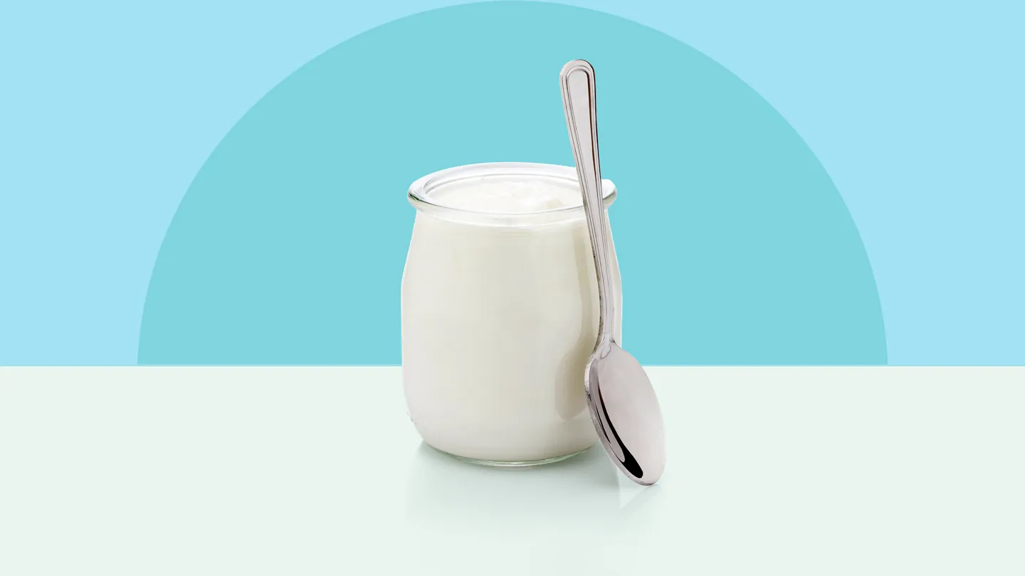 Yogurt in a glass container with spoon